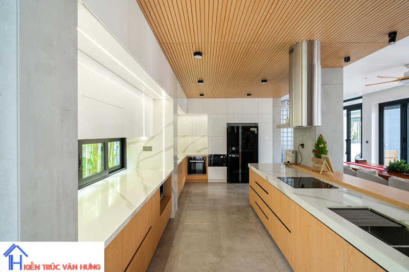 Không gian bếp thiết kế theo phong cách hiện đại với hệ tủ gỗ kết hợp mặt đá